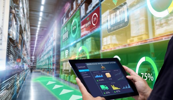 Worker hands holding tablet on blurred warehouse as background